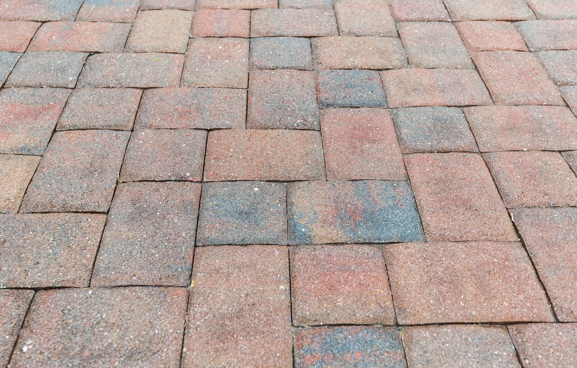 Older paving in a driveway that needs new sealant to protect it from the elements.